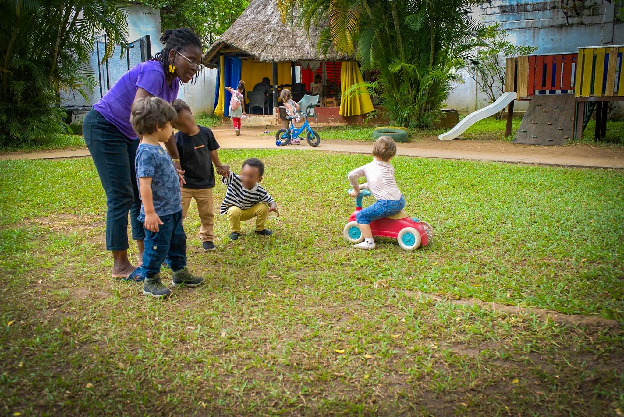 Une animatrice et des enfants dans le jardin, au matin