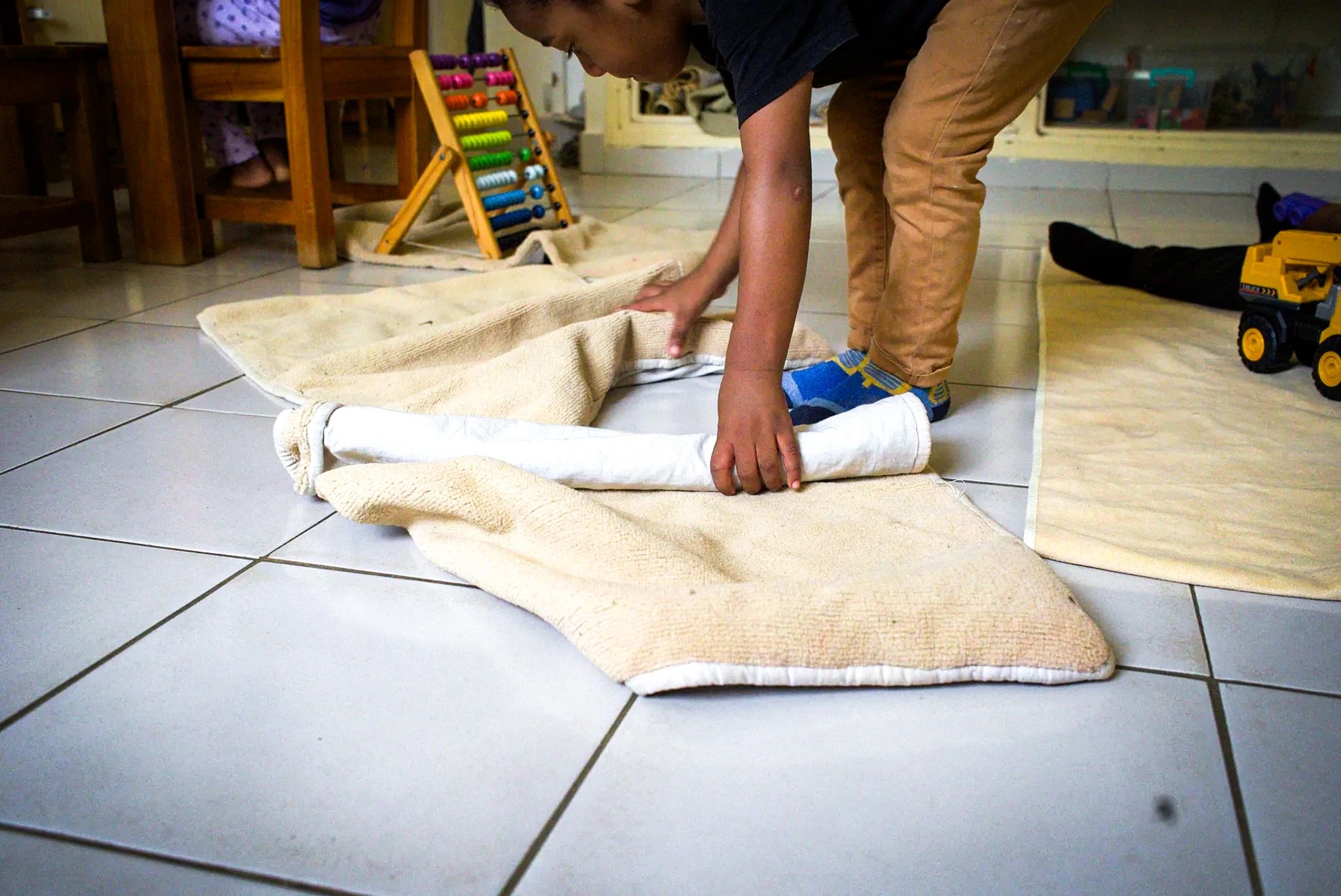 Un enfant roule seul son tapis de travail