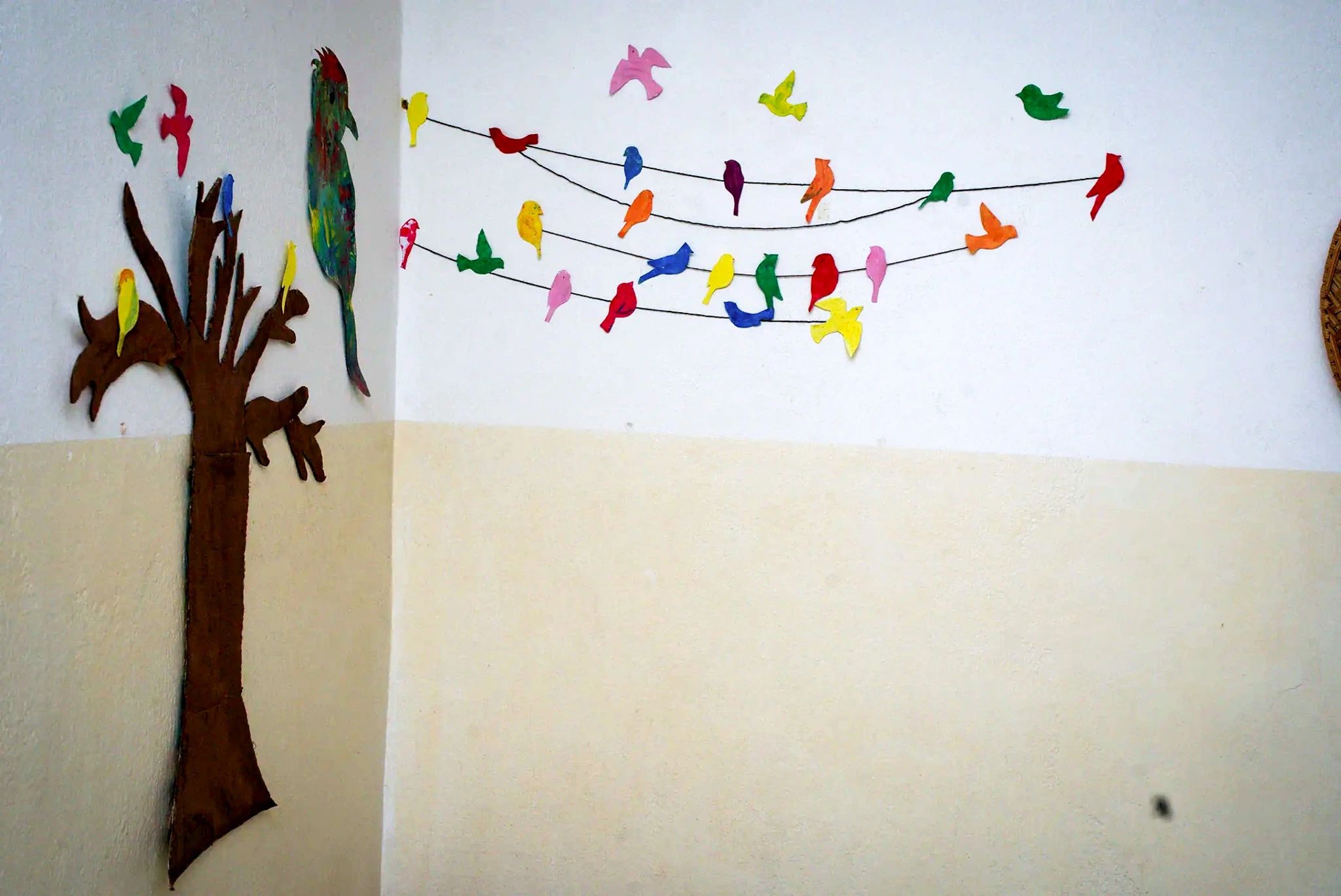 La fresque murale de la salle : un arbre découpé où sont posés des oiseaux peints à la main