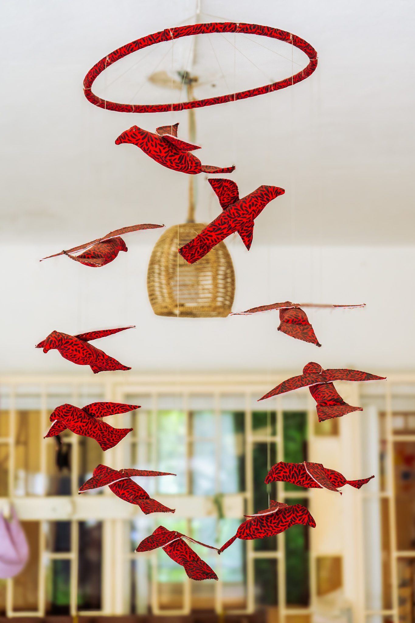 Le mobile d’oiseaux rouges suspendu dans la salle