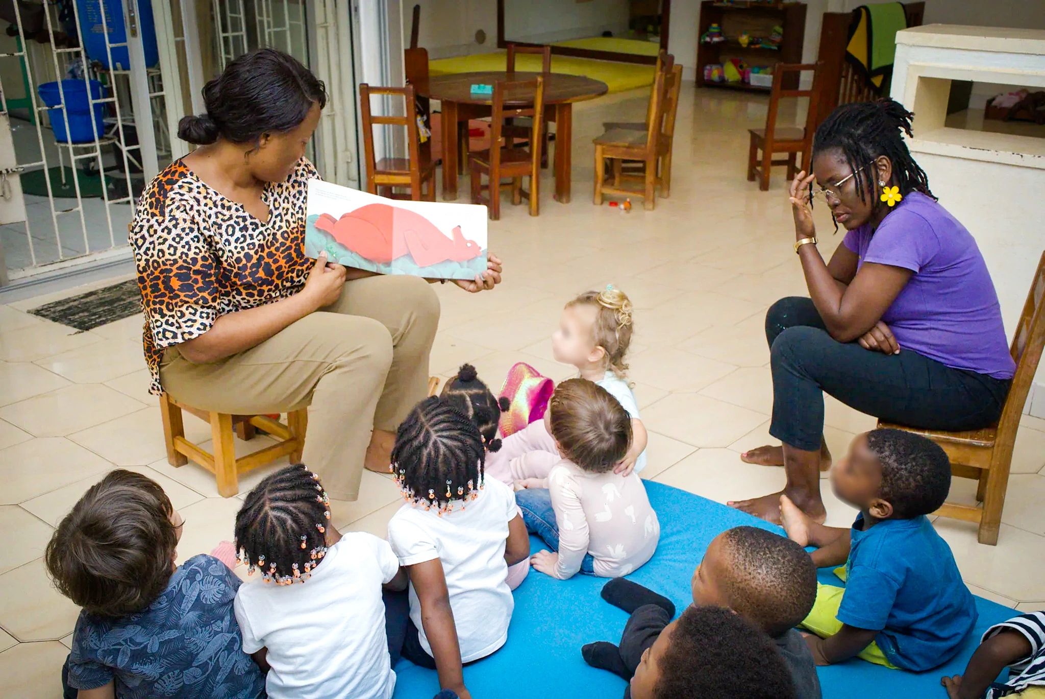 Les enfants assis en regroupement, de dos