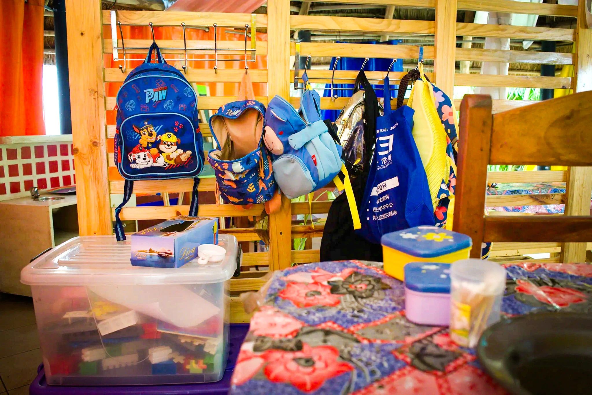 Les sacs des enfants accrochés à leur patère, à l’entrée