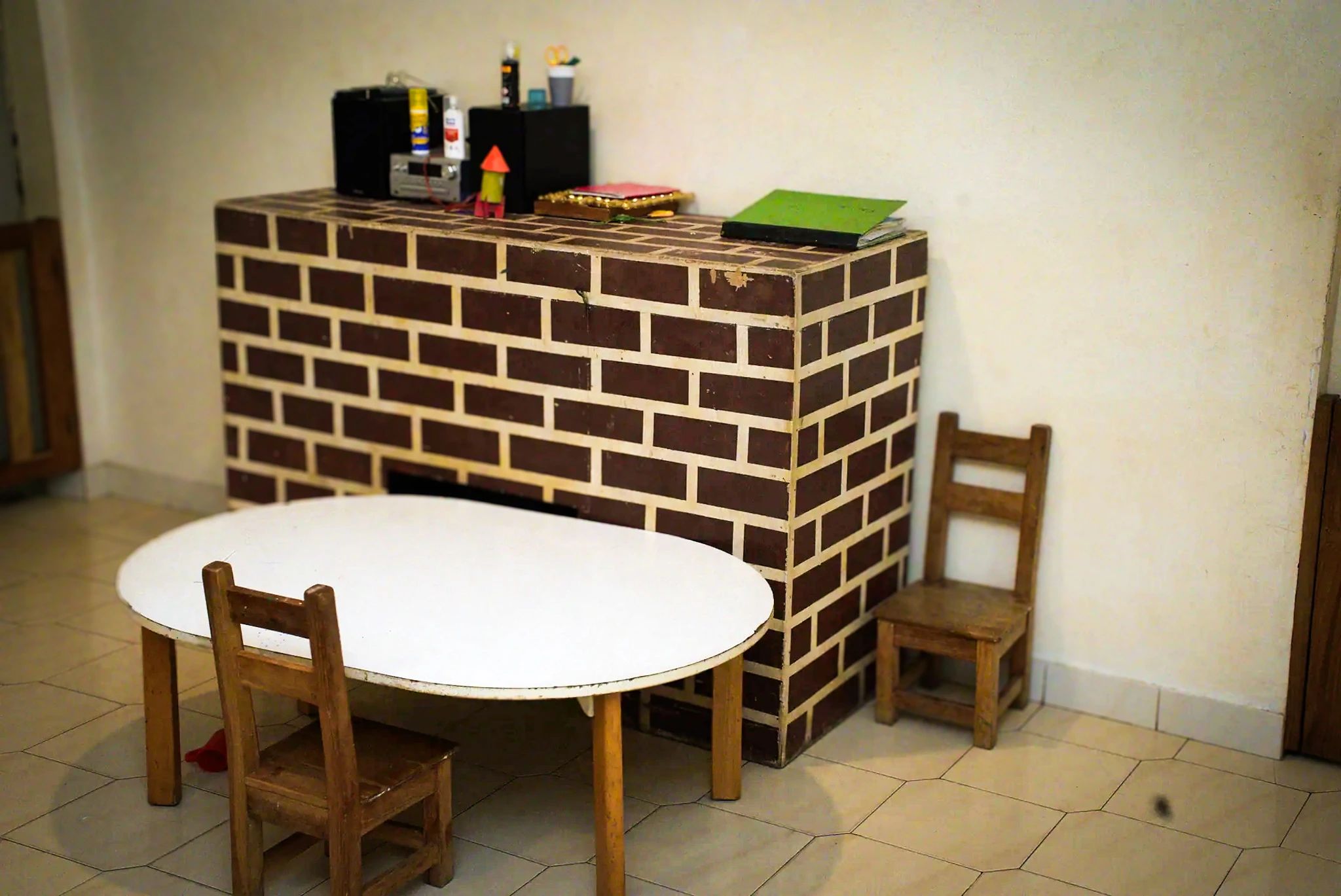 La pièce, sa table ronde et son mur de brique